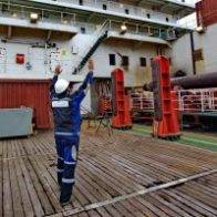 The worker shows where to put freight. Deck of the pipelaying vessel.