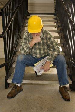 Construction worker contemplating his next move after being laid off.