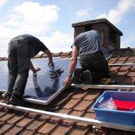 Two workers installing solar panels.