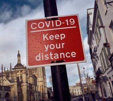 CAMBRIDGE, ENGLAND - NOVEMBER 10: A sign indicates keeping a safe distance on November 10, 2020 in Cambridge, England. England entered a second national coronavirus lockdown on 5th November. People are still permitted to exercise with one other person, takeaway food is permitted but bars and restaurants are shut for sit-in service. Schools will remain open but people are being advised to work from home where possible and only undertake necessary travel. All non-essential shops are closed with supermarkets and builders' merchants remaining open. (Photo by Gareth Cattermole/Getty Images)