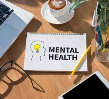 MENTAL HEALTH open book on table and coffee Business