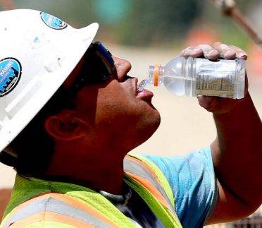 Construction worker drinking water on a hot day.