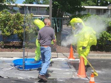 Two students being instructed on how to work with hazardous materials
